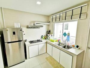 米里EcoPark Condo, 5mins to airport, malls & eatery的厨房配有冰箱和水槽