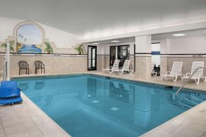 伊斯顿伊斯顿汉普顿酒店的酒店设有一个大型游泳池,配有椅子和椅子