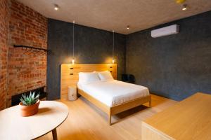 墨尔本In The Brick Spa And Hotel的一间卧室设有一张床和砖墙