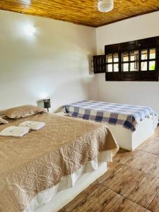 博尼托Pousada e Restaurante Alto da Serra的两张睡床彼此相邻,位于一个房间里