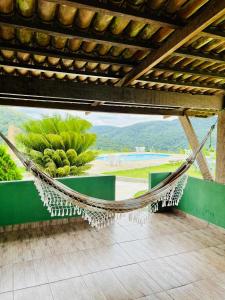 博尼托Pousada e Restaurante Alto da Serra的庭院内的吊床,享有游泳池的景色