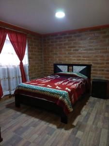 奥塔瓦洛Cozy cabin in the countryside Otavalo Learning的一间卧室配有一张砖墙床