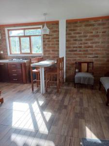 奥塔瓦洛Cozy cabin in the countryside Otavalo Learning的配有桌椅和砖墙的房间