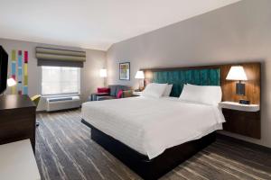 康科德Hampton Inn Concord的酒店客房设有一张大床和一张沙发。