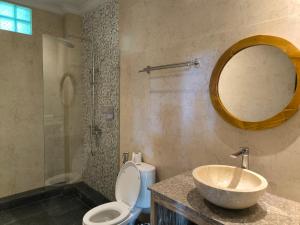 乌布彭杜克巴布家园酒店的一间带水槽、卫生间和镜子的浴室
