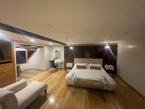 昆卡Hotel Ensueños的一间卧室配有一张床、一张桌子和一张沙发