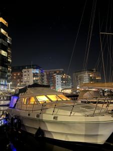 南安普敦LUXURY 40 FOOT YACHT ON 5 STAR OCEAN VILLAGE MARINA SOUTHAMPTON - minutes away from city centre and cruise terminals - Free parking included的夜间坐在水中的船