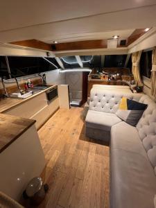 南安普敦LUXURY 40 FOOT YACHT ON 5 STAR OCEAN VILLAGE MARINA SOUTHAMPTON - minutes away from city centre and cruise terminals - Free parking included的带沙发的客厅和厨房