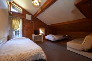 北塩原村Lake village donaludo Pension的一间卧室配有一张床,并在一间客房内配有电视。