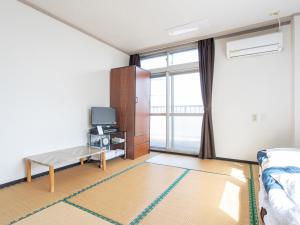 萨摩川内市HOTEL Tsuru Sendai的一间带床和电视的客厅