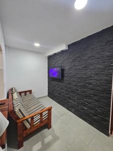卡法亚特La Emilia的一间配备有沙发的客房和带电视的墙壁