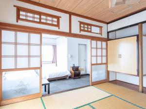 萨摩川内市HOTEL Tsuru Sendai的一间玻璃门的房间和一间卧室