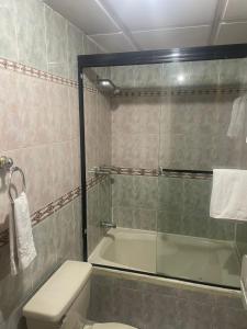 昆卡Hotel Ensueños的带淋浴、卫生间和浴缸的浴室
