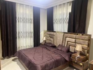 安曼Elegant apartments for rent.的一间卧室配有一张带紫色床单和窗帘的床