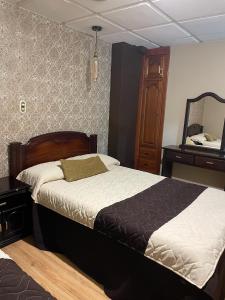 昆卡Hotel Ensueños的一间卧室配有一张床、梳妆台和镜子