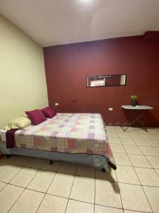 弗洛勒斯Habitación Privada Andrea, en la Isla的一间卧室设有一张床和红色的墙壁