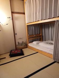 中津川市马笼茶屋的一间卧室配有两张双层床和一本书