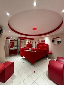 梅塞德斯镇Hotel venus的一间卧室配有红色的床和红色椅子