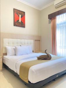 SentoolAyuri Hotel Malioboro的卧室设有一张大白色的床和大窗户