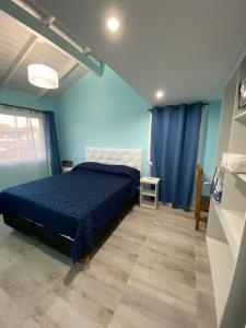 迪娜·瓦皮Alfa & Omega的蓝色的卧室,配有床和蓝色的墙壁