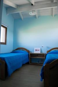 迪娜·瓦皮Alfa & Omega的蓝色墙壁客房的两张床