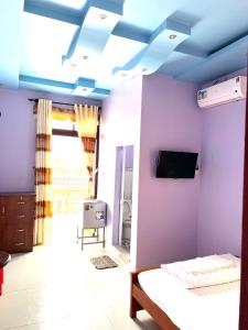 Ấp Tân Phú (1)Khách Sạn Như Ý的一间卧室设有紫色墙壁和蓝色天花板