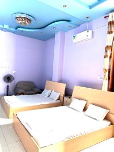 Ấp Tân Phú (1)Khách Sạn Như Ý的客房设有两张床和蓝色的天花板。