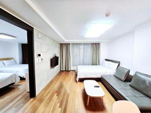 釜山Jeoung's House的酒店客房,设有两张床和一张沙发