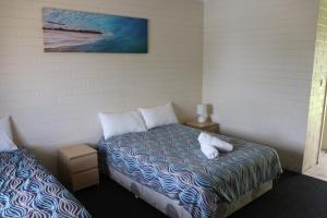 沃拉鲁垂钓者汽车旅馆的一间卧室配有一张带两个白色枕头的床