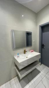 Al ‘Uqūlشقة غرفتين وصاله的浴室设有白色水槽和镜子