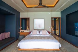 拉斯杜Veligandu Maldives Resort Island的一间卧室配有一张大床和一张沙发