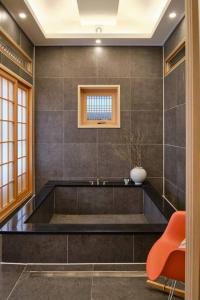 GongjuHongsi Art House的浴室配有带花瓶的大浴缸