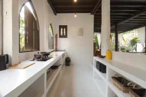 清迈Illui - Exclusive Estate in Chiang Mai - 8 Bedroom的厨房配有白色的柜台、窗户和水槽。