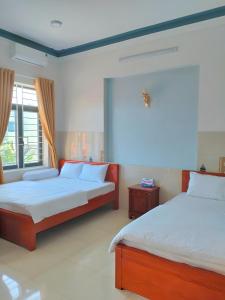 广义Khách sạn Thảo Trang的一间卧室设有两张床和窗户。