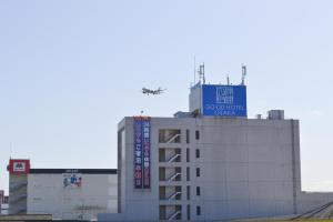 丰中グッドホテル大阪的飞机飞越了一座建筑物