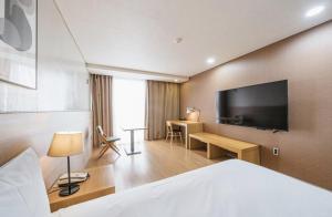 济州市S Hotel的配有一张床和一台平面电视的酒店客房
