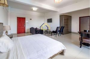 罗安达Hotel Kilimanjaro - Luanda Angola的卧室配有白色的床、书桌和椅子