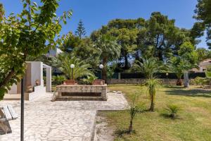 维耶斯泰Villa Soleanna Residence的庭院里种有长凳和树木的花园