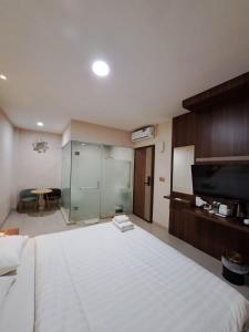 巴淡岛中心Hotel Morena Batam的卧室配有一张白色的大床和一张桌子