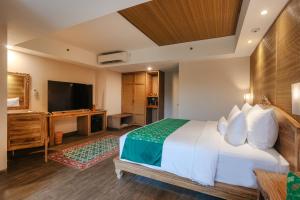 乌布Horison Ume Suites & Villas的配有一张床和一台平面电视的酒店客房