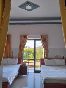 广义Khách sạn Thảo Trang的一间卧室设有两张床和大窗户