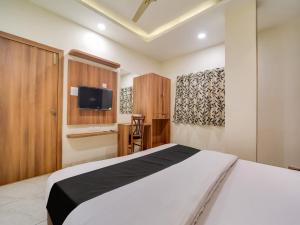 博帕尔Collection O Zamzam Residency的卧室配有白色的床和电视