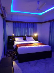 比拉特纳加尔Royalwood City Inn的一间卧室配有一张蓝色的大床