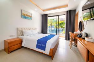 富国Hana Hotel Sonasea Night Market Phu Quoc的一间卧室配有一张床、一张书桌和一个窗户。