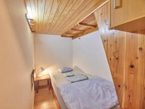 ItoshimaItosima Guesthouse TOMO的一间小卧室,配有一张床和木制天花板