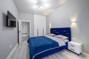 阿拉木图Апартаменты на Гагарина的一间卧室配有蓝色的床和电视