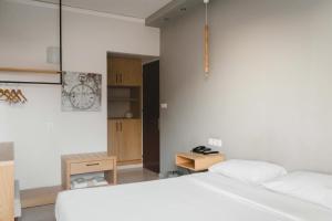 美西尼Messini Hotel的卧室配有白色的床和木制橱柜。