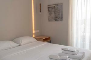 美西尼Messini Hotel的一张白色的床,上面有两条毛巾