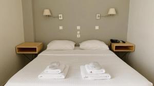 美西尼Messini Hotel的一间卧室配有带毛巾的床