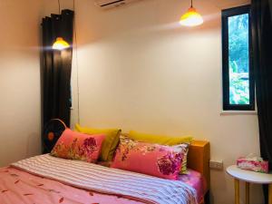 帕干岛Simple Garden Resort的一间卧室配有带色彩缤纷枕头的床